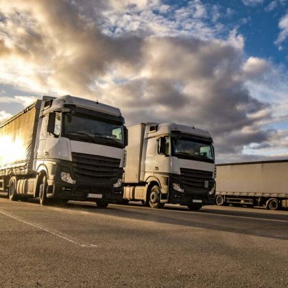 Trucks,In,A,Row,With,Containers,In,The,Parking,Lot.